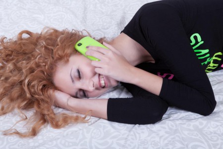 Сладкая кудрявая рыжая малышка Tofana A раздевается на кровати и трахает пальчиками свою киску