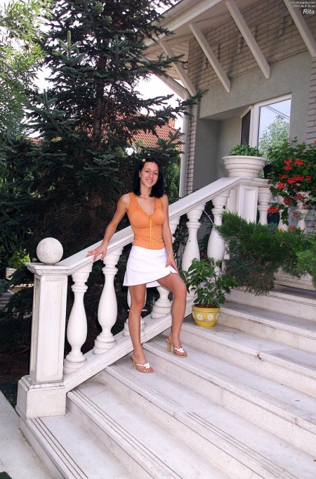 Милая брюнетка с большими натуральными сиськами Afrodite Night позирует обнаженной на ступеньках на улице