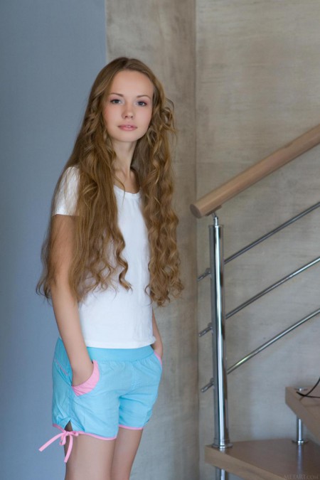 Похотливая, молодая куколка с кудрявыми волосами Virginia Sun снимает корсет и трусики, затем сексуально позирует