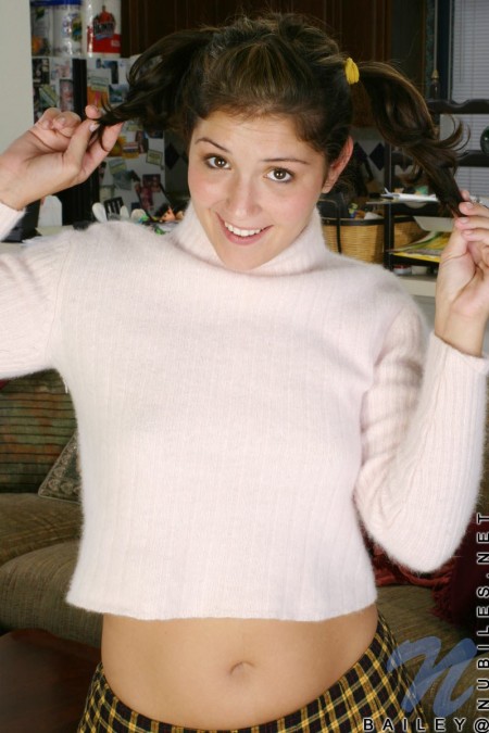 Шаловливая брюнетка Bailey Nubiles со смешными хвостиками снимает клетчатую юбку и показывает лобок