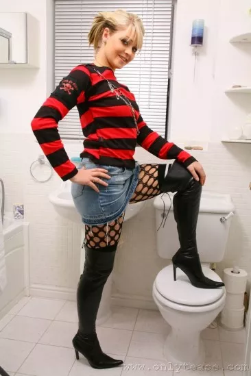 Игривая куколка Melissa Onlytease в колготках в сеточку и белых трусиках показывает свои буфера в туалете