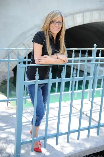 Знойная детка в очках и с гладкой киской Leslie FTV полностью раздевается под мостом