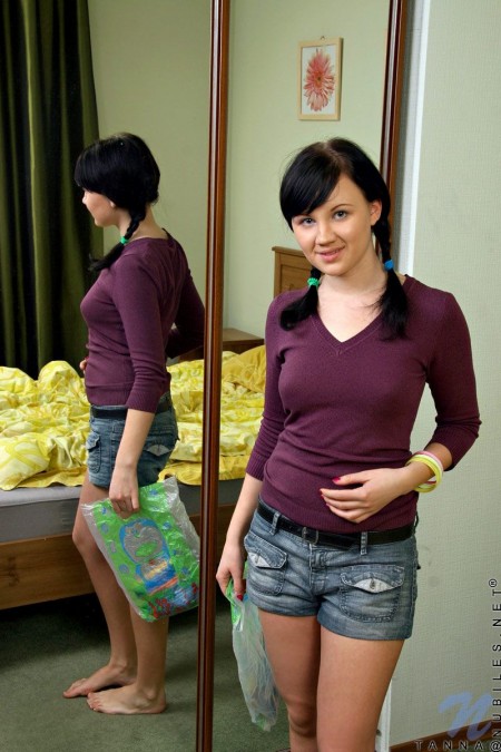 Темноволосая малолетка Tanna Nubiles оценивает свою очаровательную попку и безволосую киску в зеркале