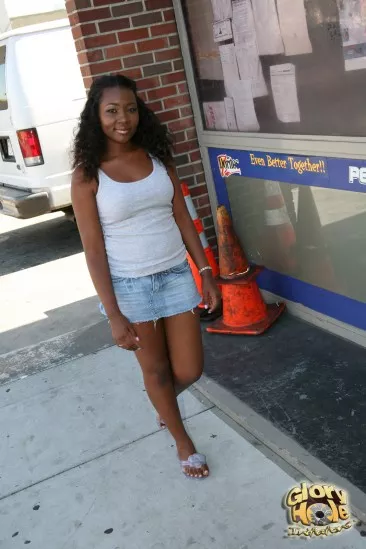 Сексуальная,  черная цыпочка Sunny Knight заглатывает член, торчащий из дырки полностью и получает камшот на свои титьки